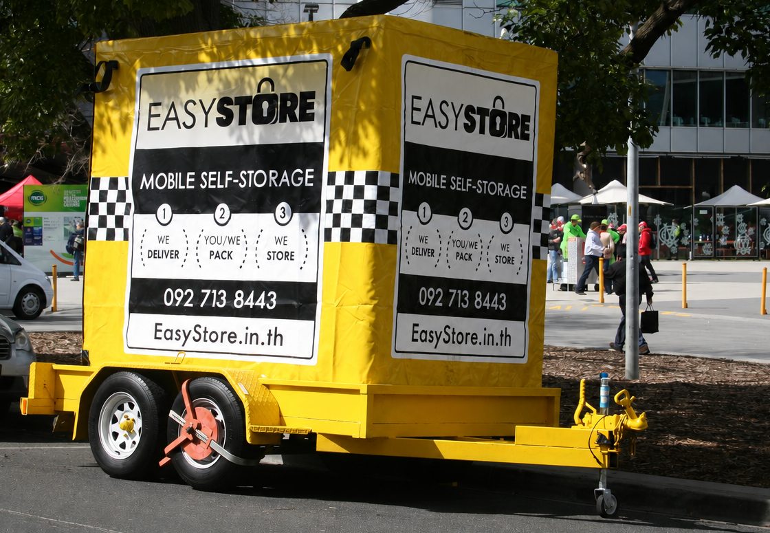 EasyStore self storage delivery trailer parked on a street ready to drop off a storage box